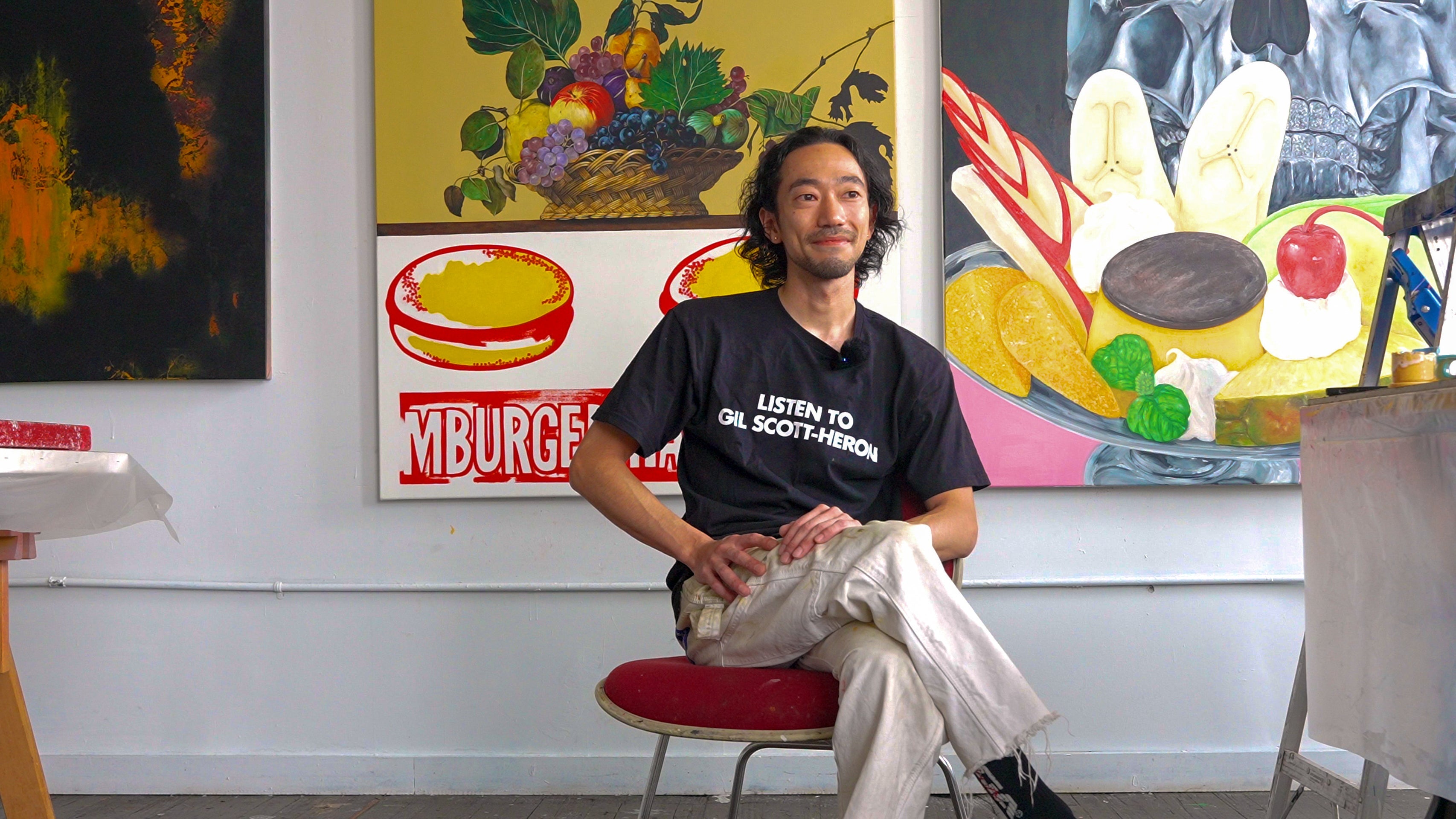 Toya Horuchi sitting on a chair inside his art studio