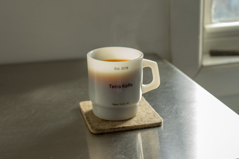 White mug of coffee on metal table