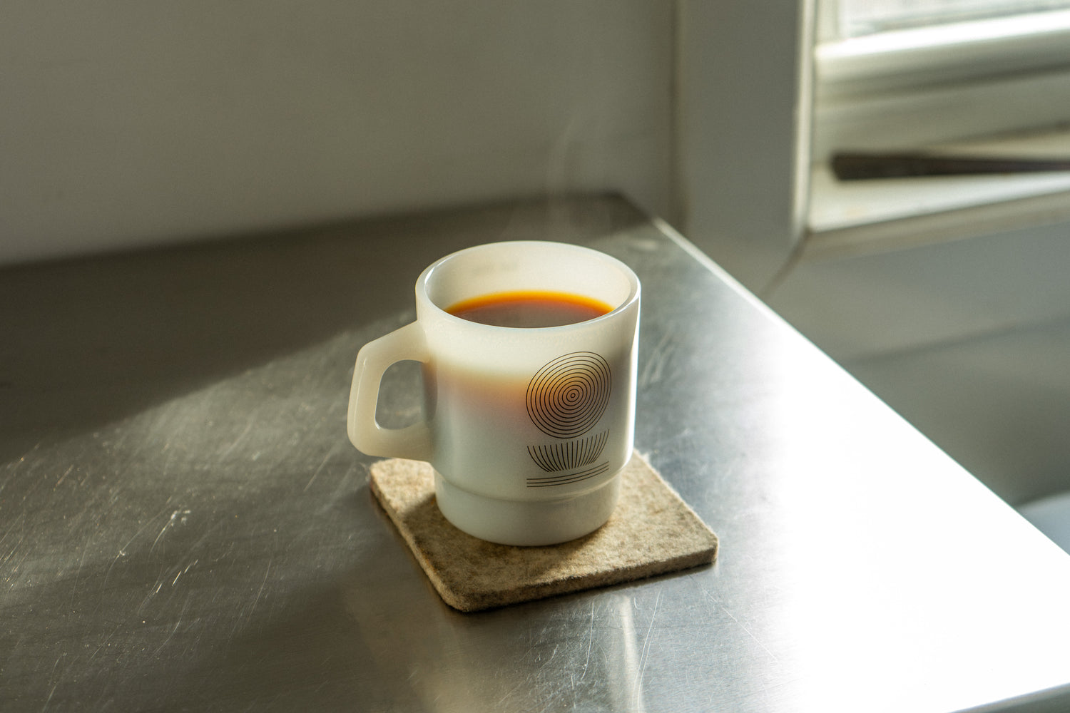 White mug of coffee on metal table